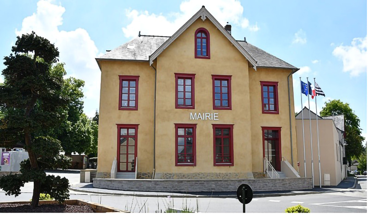 Photo d'une mairie typique en France, bâtiment en pierre beige avec des encadrements de fenêtres rouges et un toit en ardoise. Le mot 'MAIRIE' est affiché en façade. Les drapeaux français et breton flottent à droite du bâtiment, symbolisant l'ancrage local et institutionnel. Illustration idéale pour évoquer l'accompagnement des collectivités territoriales par Frédérique Capelle, consultante juriste en marchés publics.